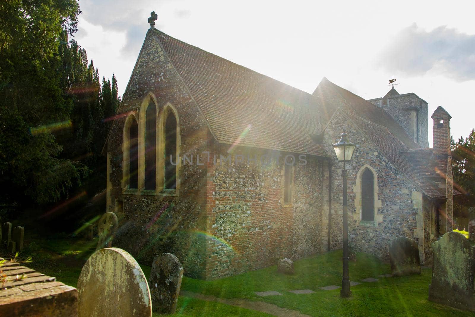 Wide-shot of St Martin Church at Canterbury with the sun flaring in the background