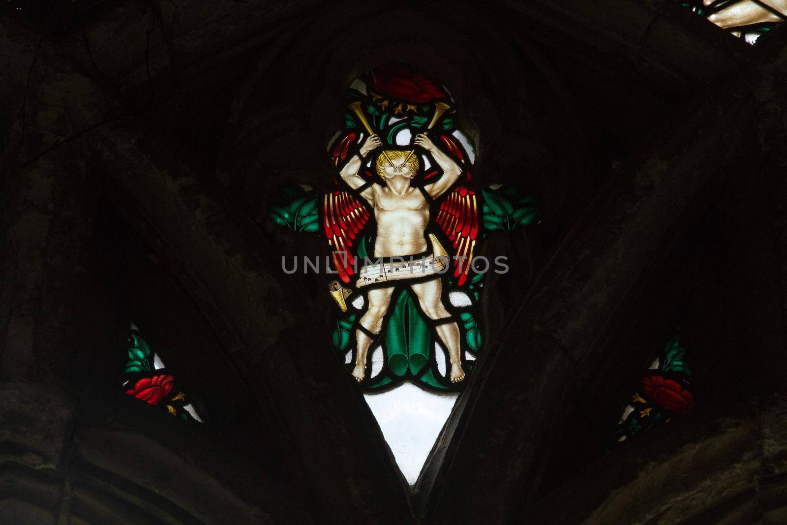 Detail of an angel playing the trumpets on an old stained window