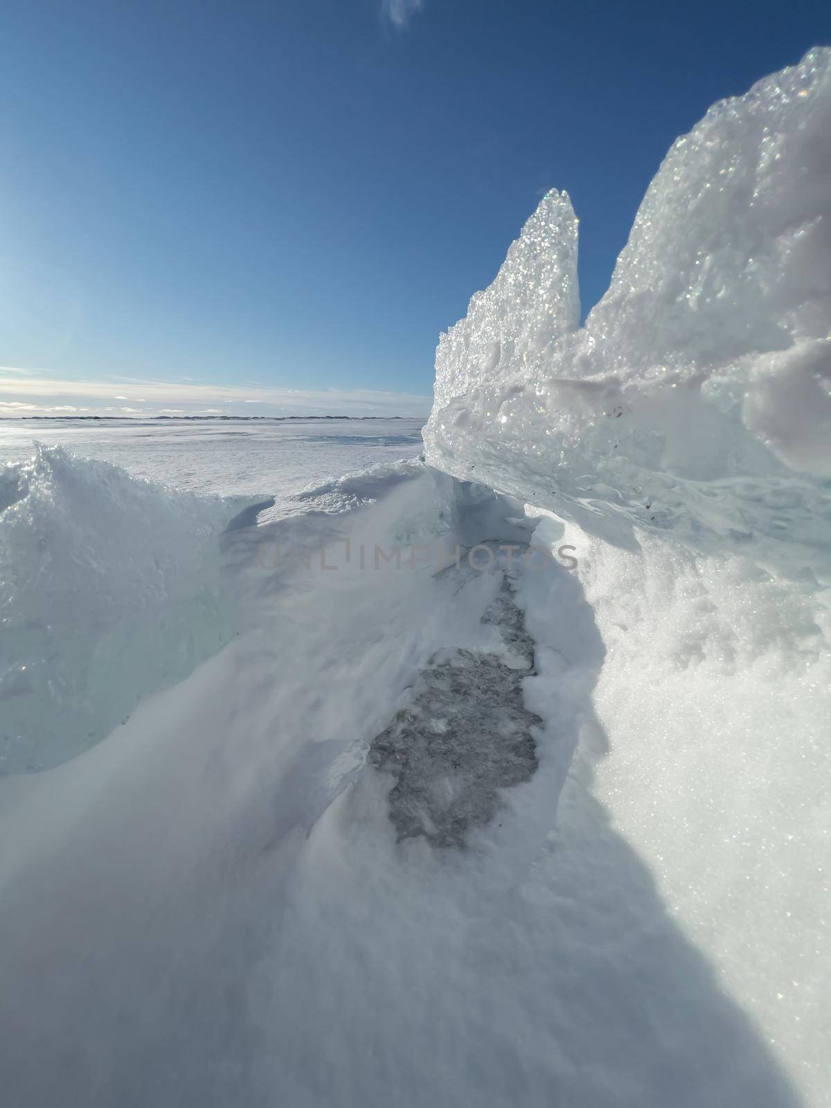 Ice slopes in sunny winter day, transparent ice of blue color, purely blue sky, long shadows, a pure snow-covered virgin soil, snow barkhans, . High quality photo