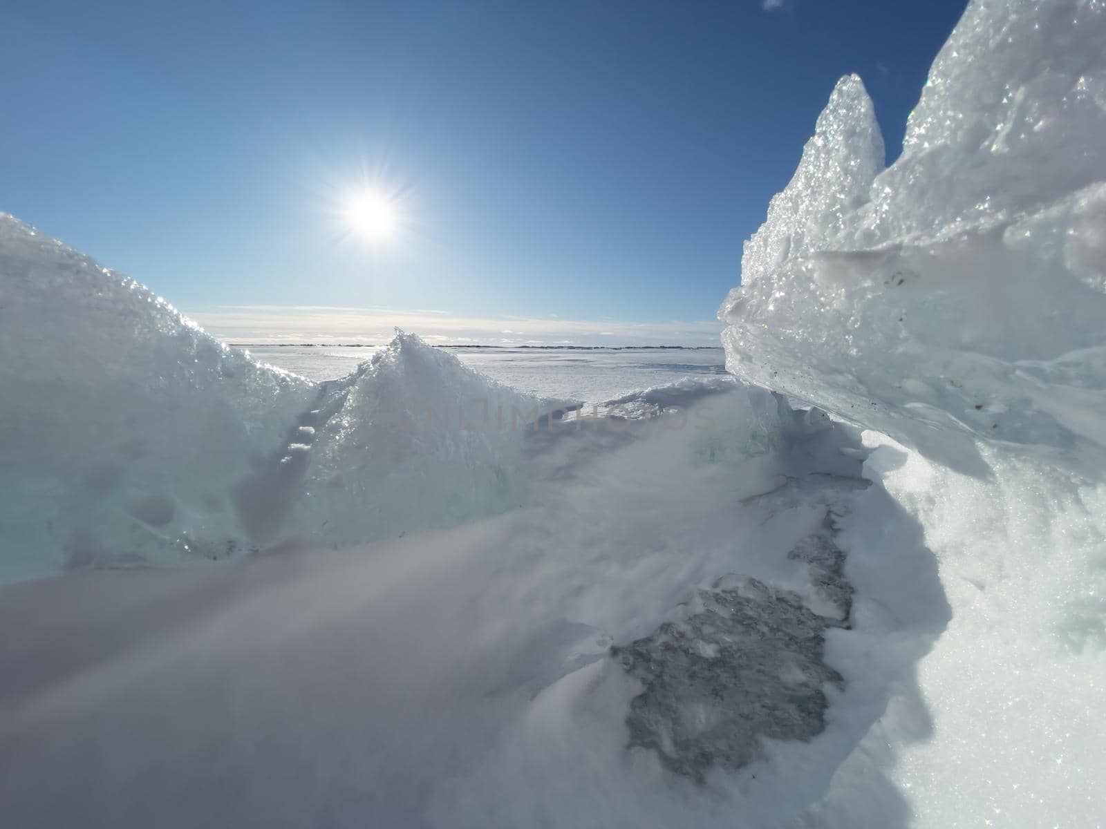 Ice slopes in sunny winter day, transparent ice of blue color, purely blue sky, long shadows, a pure snow-covered virgin soil, snow barkhans, . High quality photo