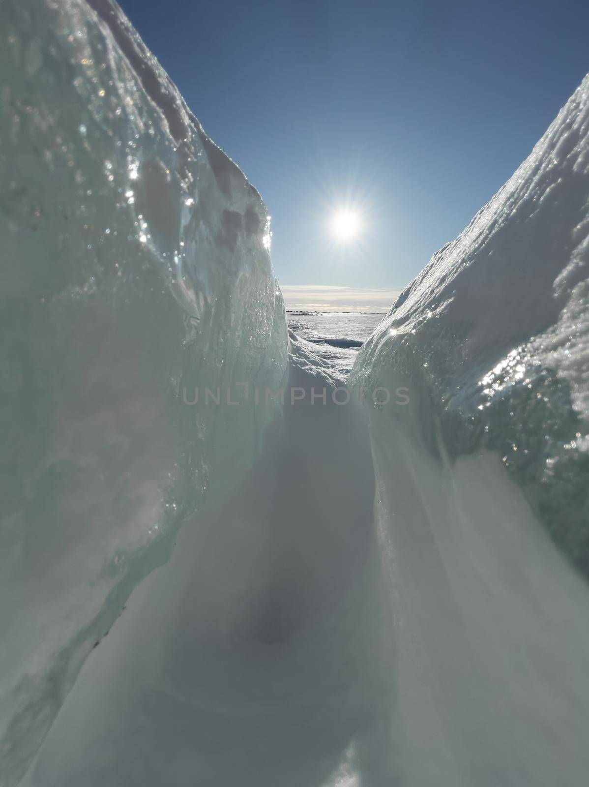 Ice slopes in sunny winter day, transparent ice of blue color, purely blue sky, long shadows, a pure snow-covered virgin soil, snow barkhans, . High quality photo