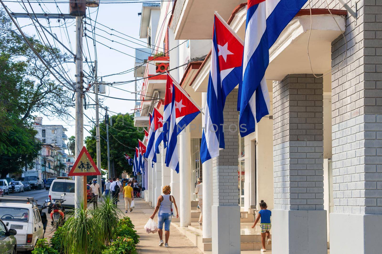 Havana Cuba. November 25, 2020: Cuban flags waving on the facade of buildings on Ayestaran Avenue. Trimagen Company