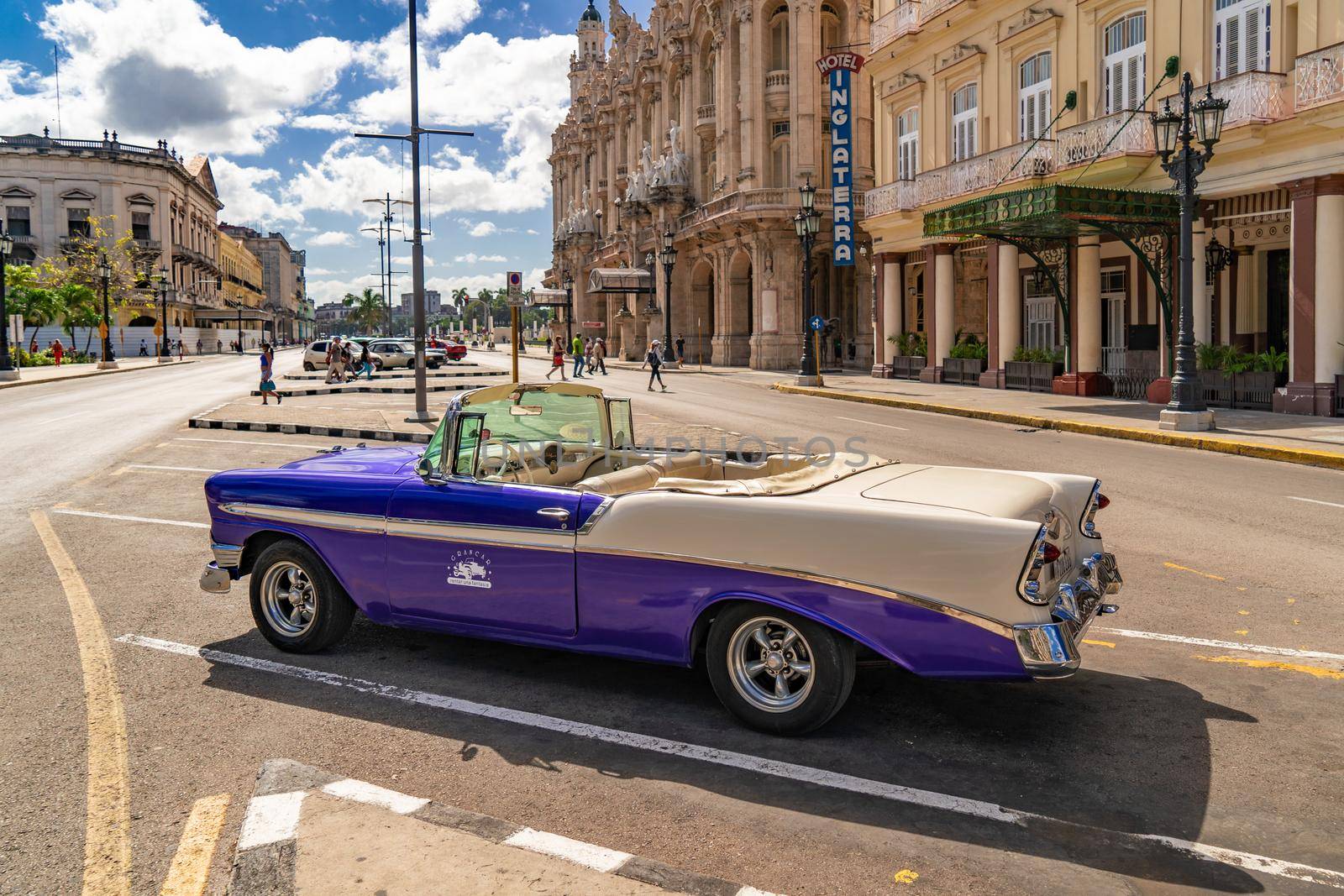 Havana Cuba. November 25, 2020: Old car from the Gran Car agency parked on an avenue in Havana with the Inglaterra hotel and the Gran Teatro de la Habana in the background