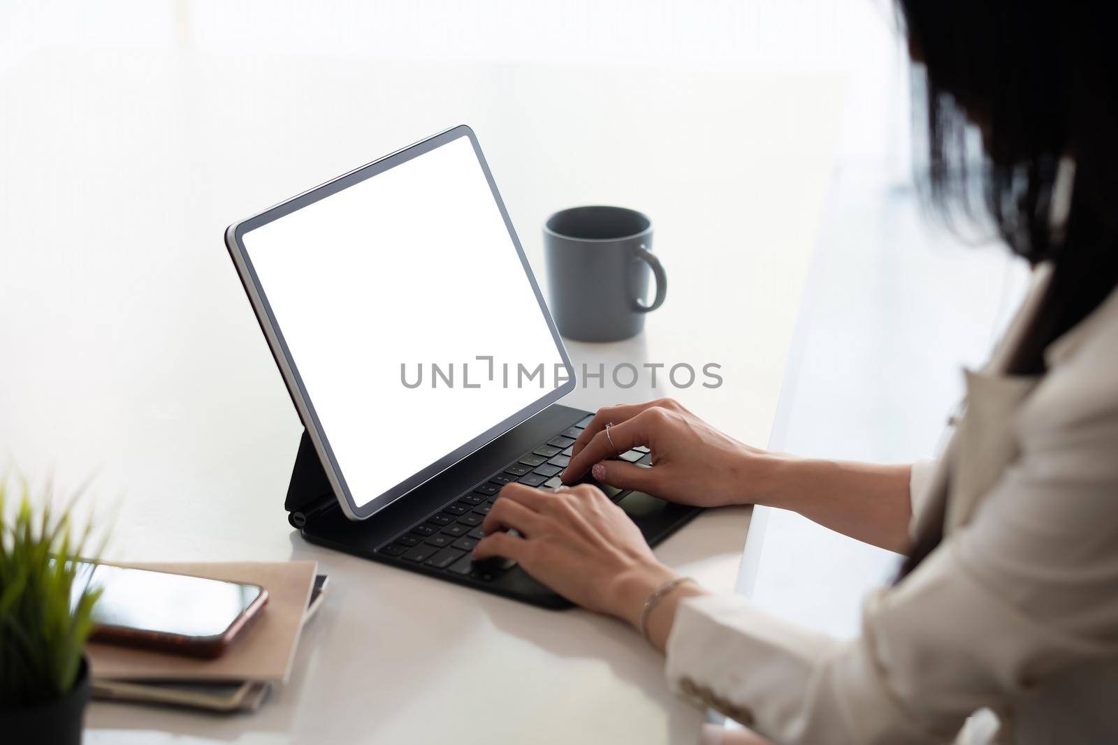 Close up businesswoman using digital tablet with blank white screen at office.