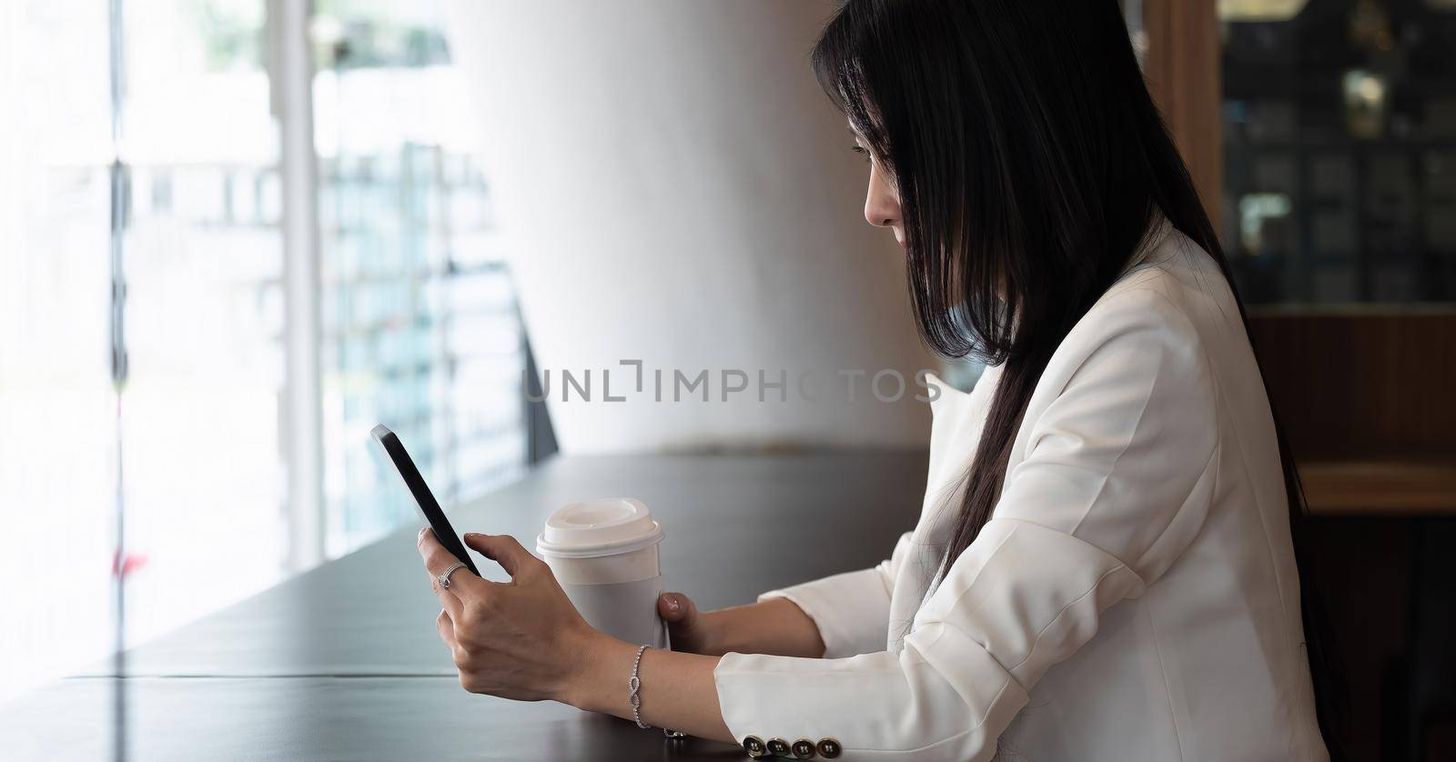 Shot of businesswoman using smartphone for video calling during working from home. by nateemee