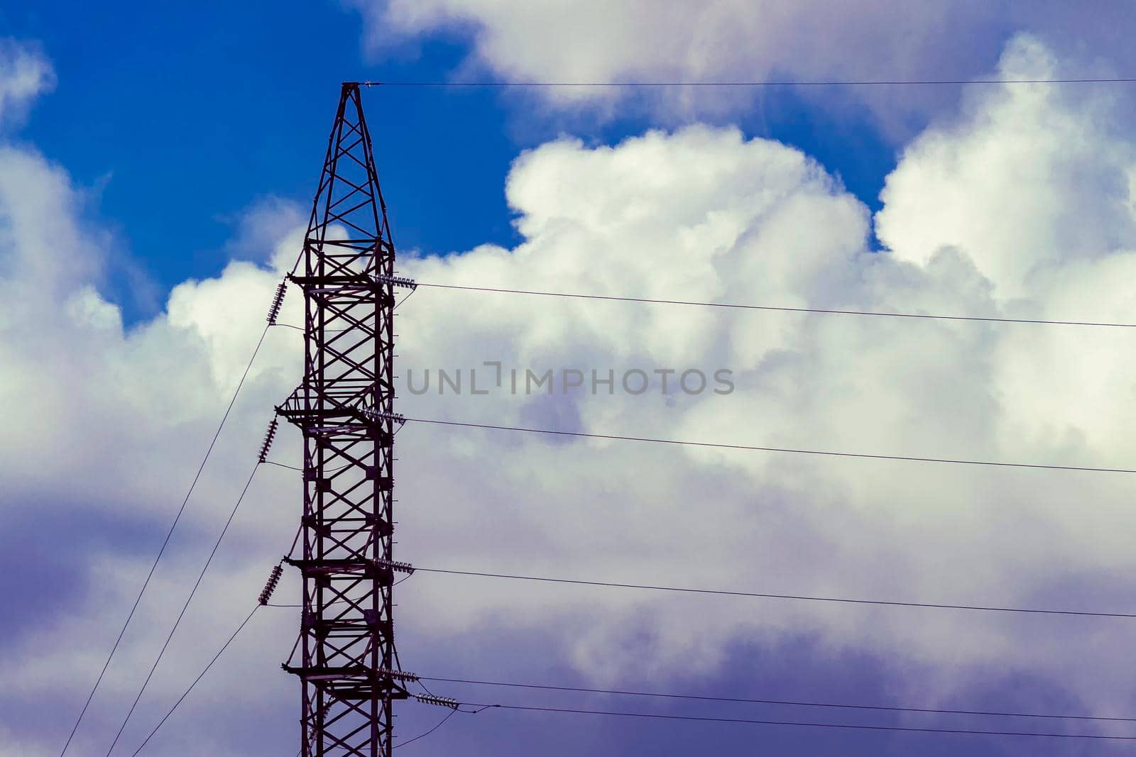 A high-voltage tower against a cloudy sky.