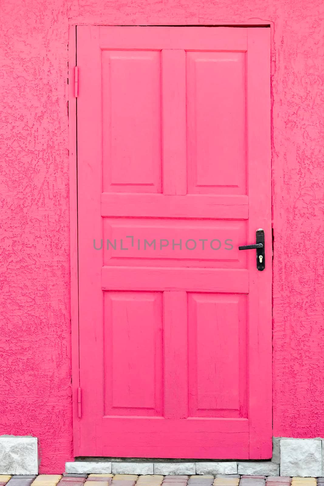 A pink wooden door. View from the front under the bright daylight sun. by Essffes