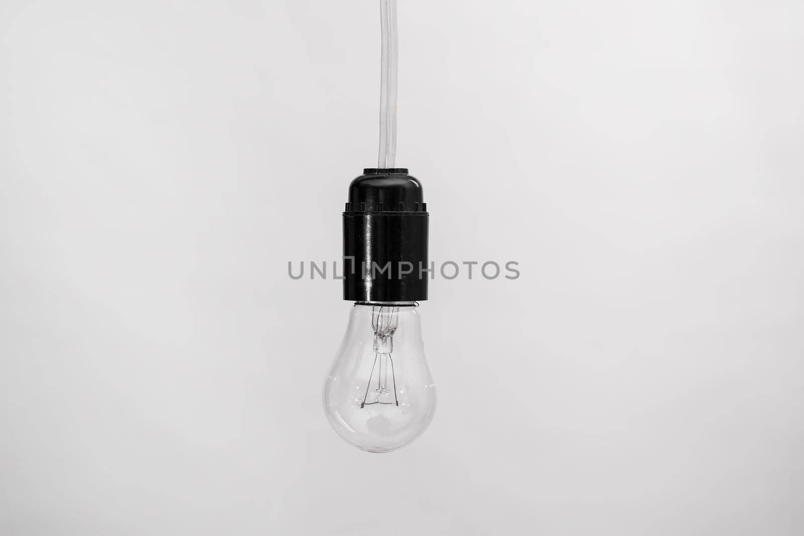 incandescent lamp with a cartridge on the wire isolated on white background. The spiral is not damaged. horizontal