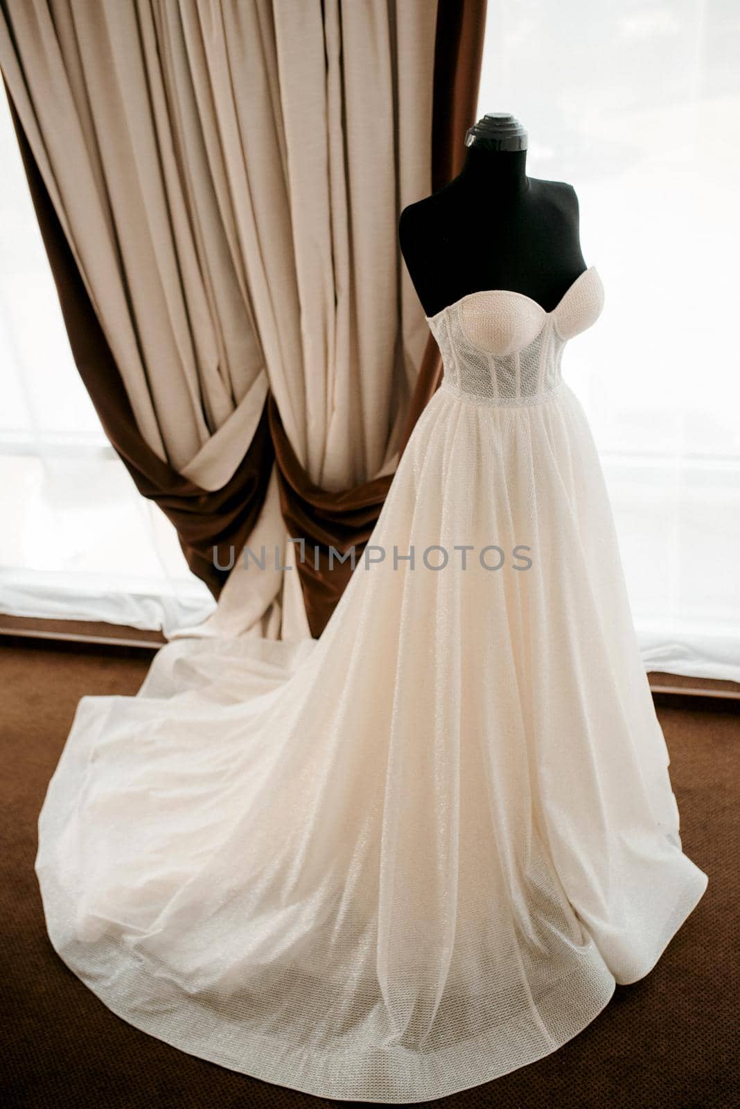 ivory wedding dress with a train on a black mannequin