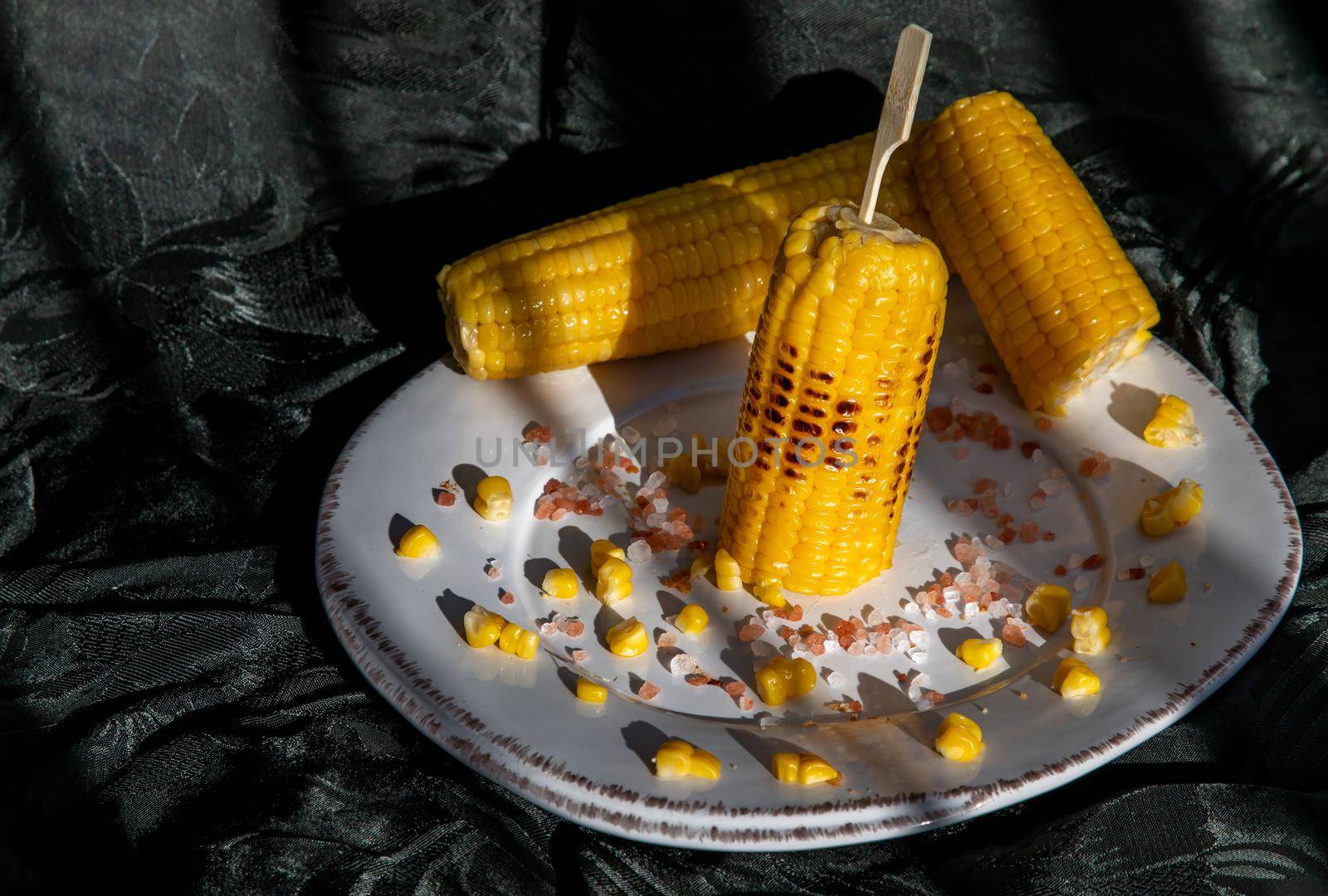 Grilled corn on the cob  on classic white plate over dark background. by tosirikul