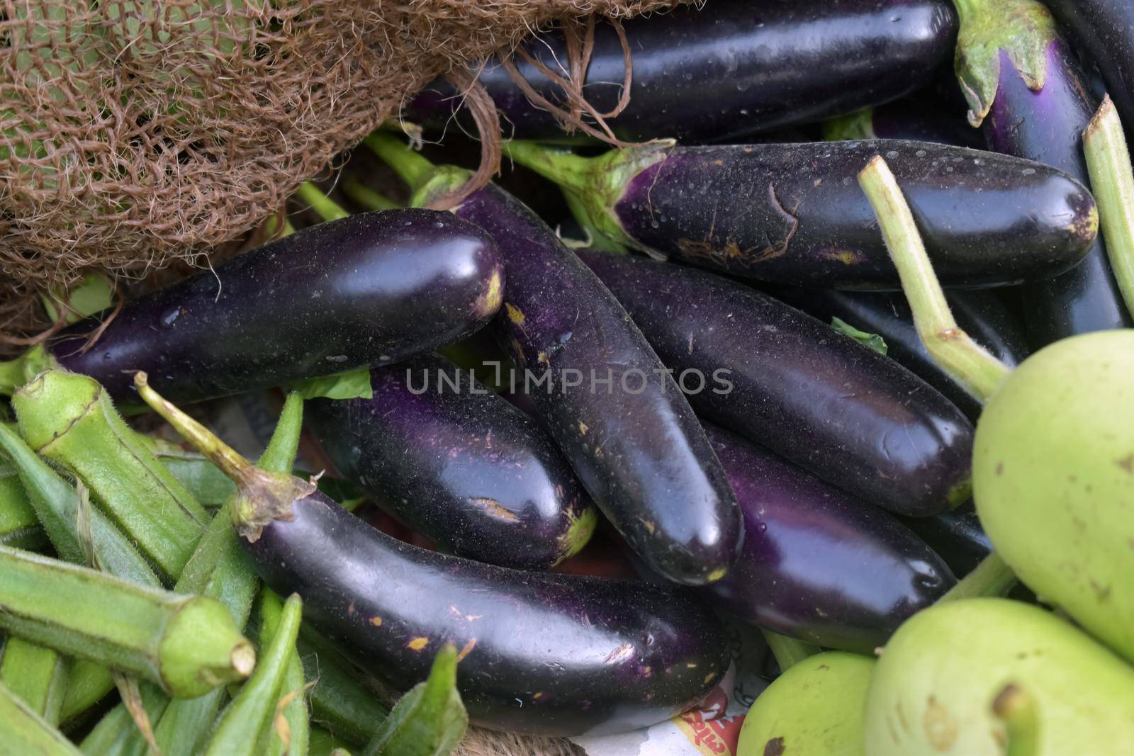 A closeup shot of a pile of fresh eggplants in a market place