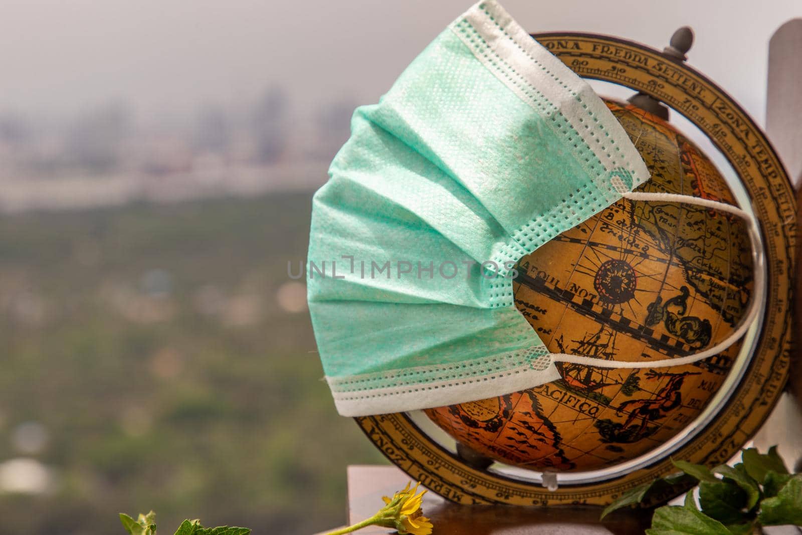 Bangkok, Thailand - Jun 25, 2020 : The globe is wearing a disposable medical mask. Concept of prevent spread of corona virus covid-19. Everyone should wear mask in public. Coronavirus pandemic, World quarantine, Selective focus. Copy space.