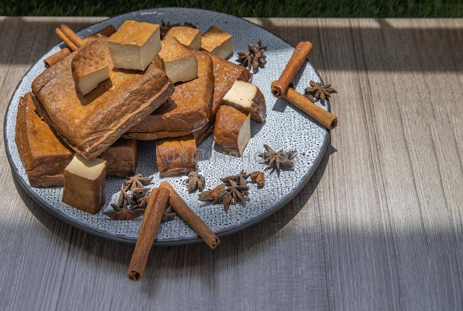 Traditional black herb tofu on ceramic plate. Culinary vegan and vegetarian eating.