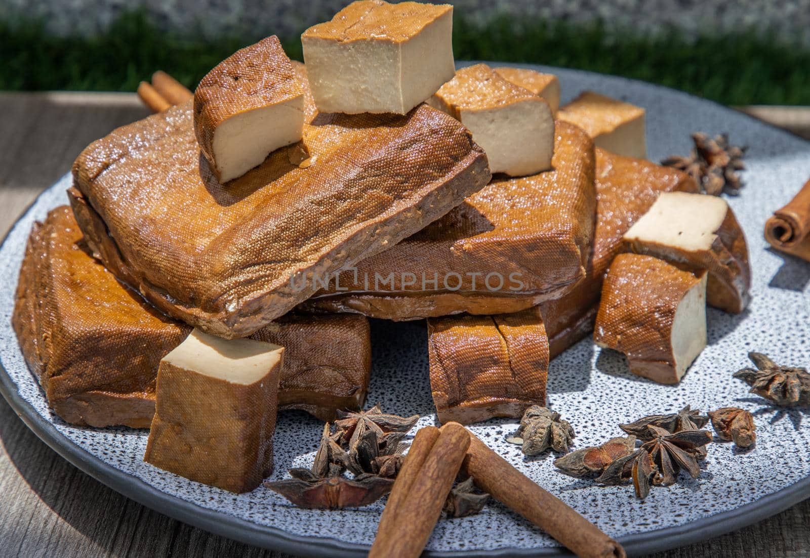 Traditional black herb tofu on ceramic plate. Culinary vegan and vegetarian eating.