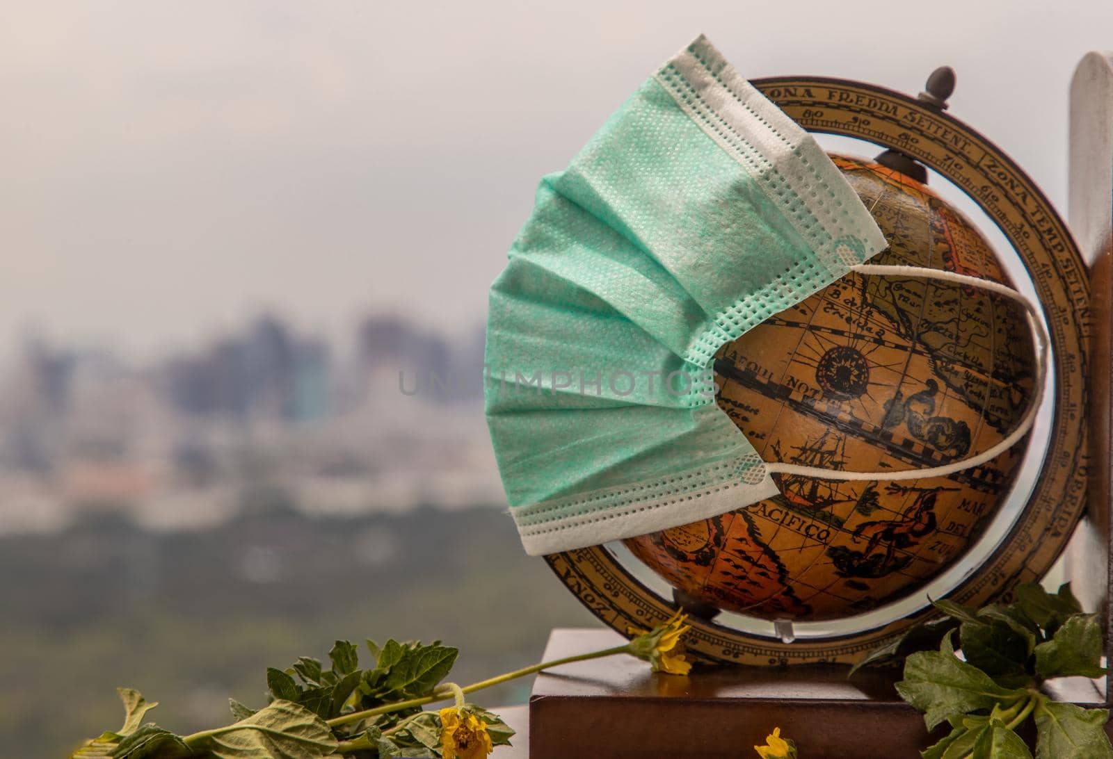 Bangkok, Thailand - Jun 25, 2020 : The globe is wearing a disposable medical mask. Concept of prevent spread of corona virus covid-19. Everyone should wear mask in public. Coronavirus pandemic, World quarantine, Selective focus. Copy space.