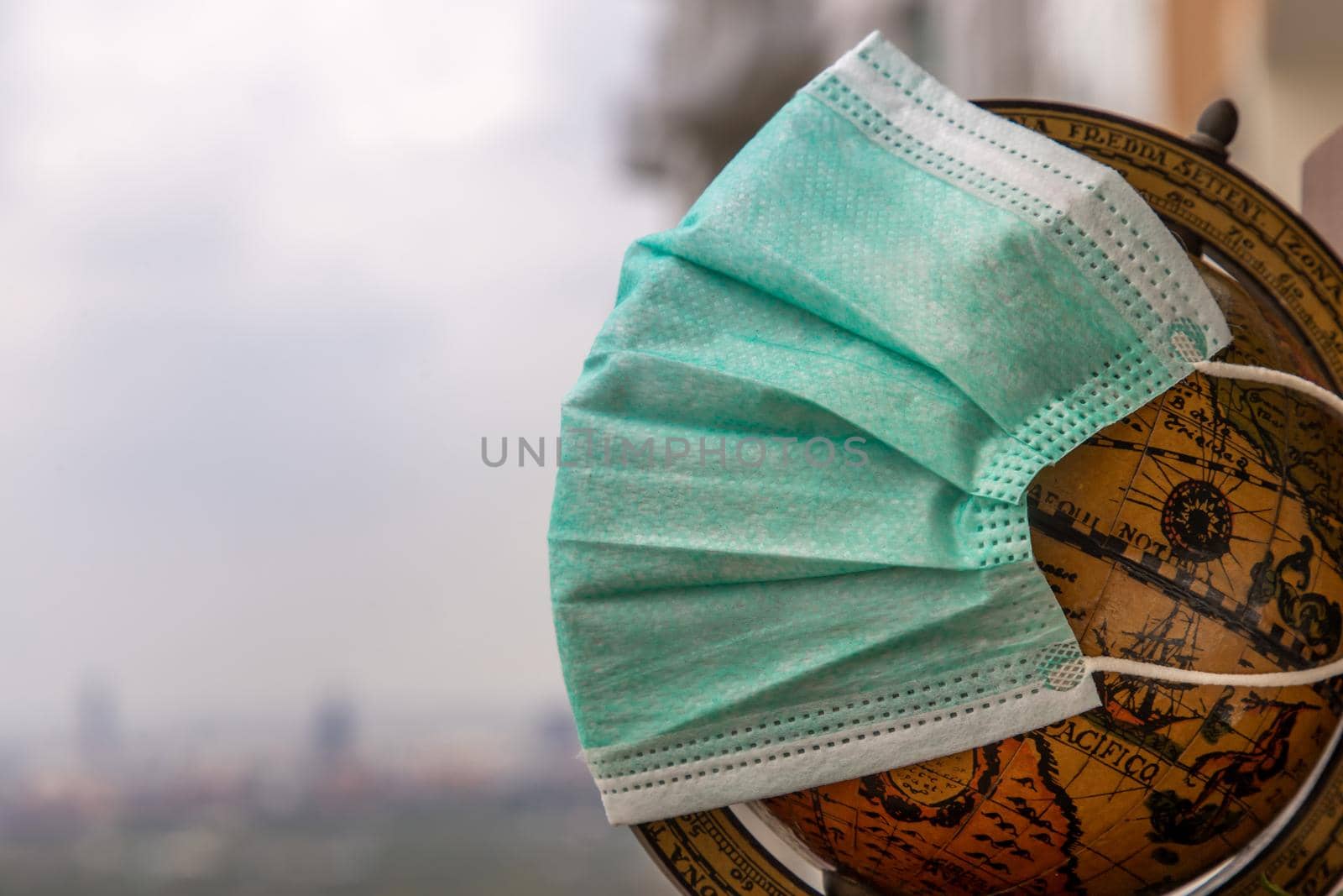Bangkok, Thailand - Jun 25, 2020 : The globe is wearing a disposable medical mask. Concept of prevent spread of corona virus covid-19. Everyone should wear mask in public. Coronavirus pandemic, World quarantine, Selective focus. Copy space.