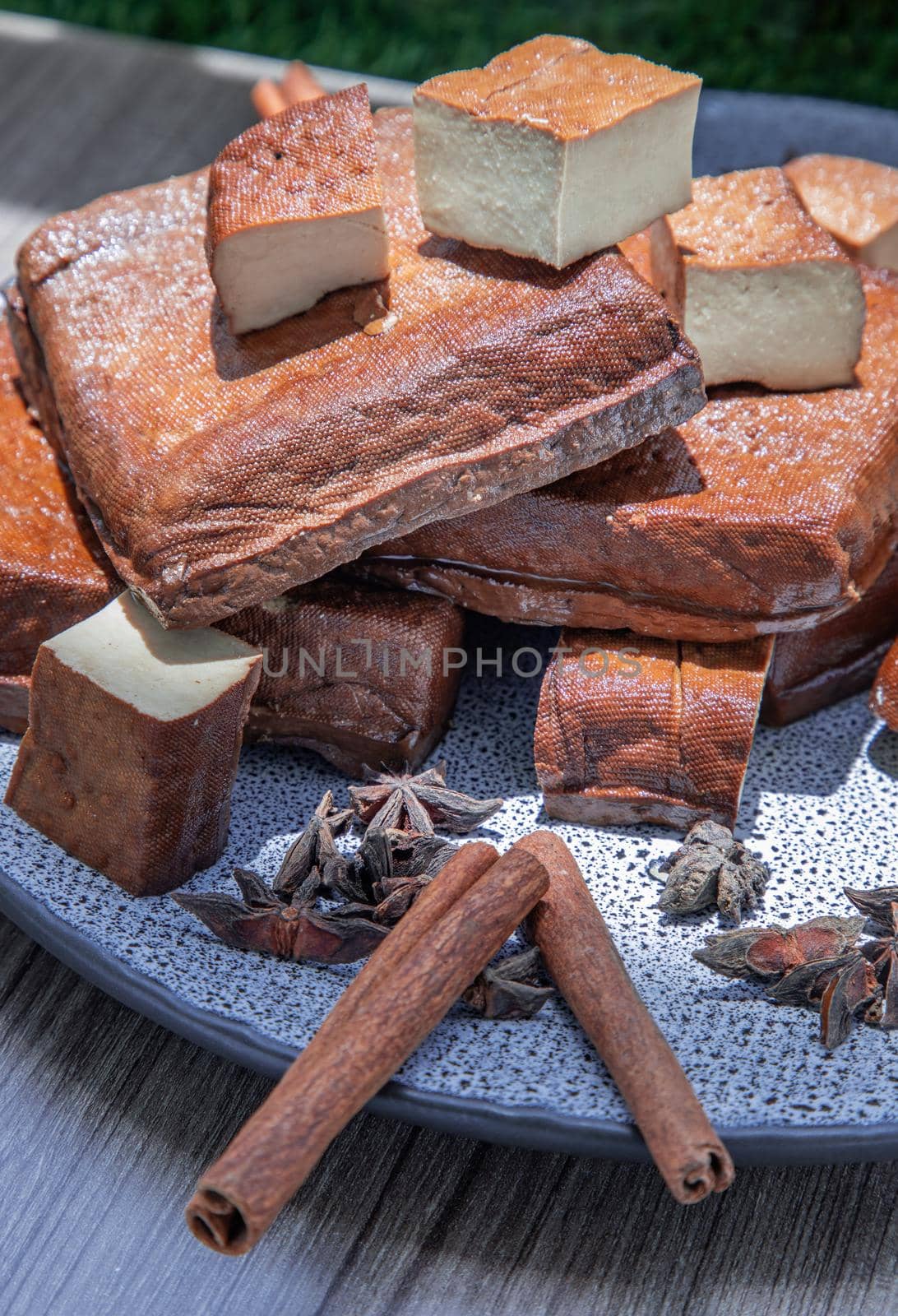 Traditional black herb tofu on ceramic plate. Culinary vegan and vegetarian eating.