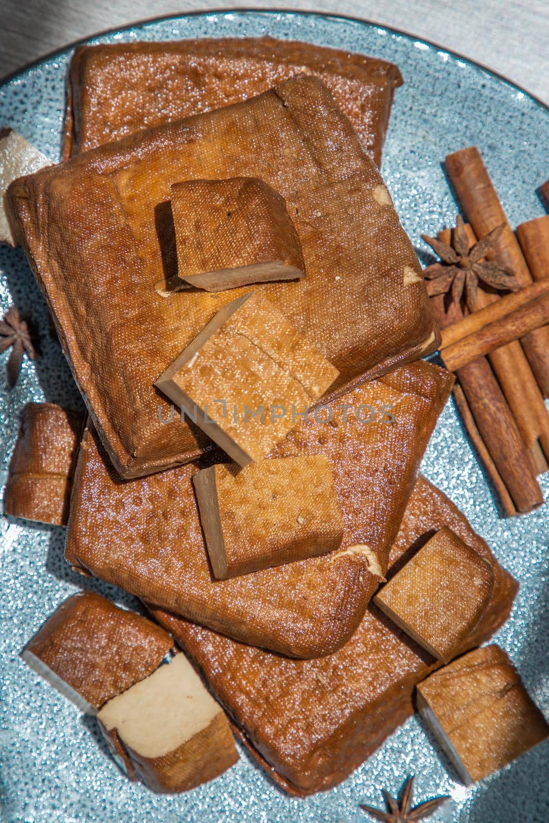 Traditional black herb tofu on ceramic plate. Culinary vegan and vegetarian eating.