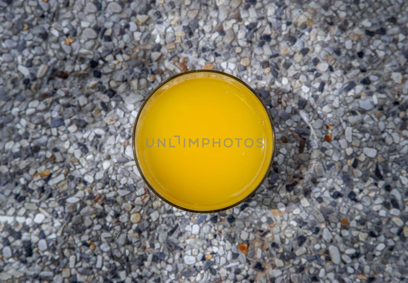 A glass of fresh orange juice with flower for a refreshment on stone background. leisure activity.