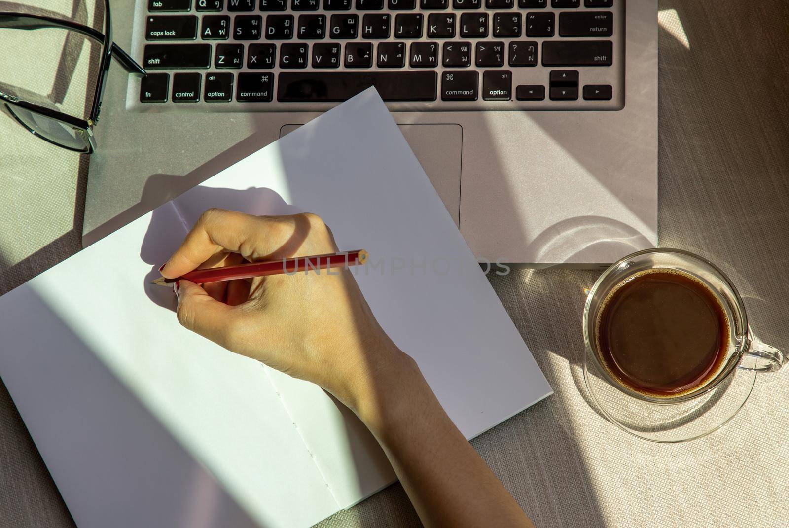 Hand of business woman writing on paper at her workstation. business concept.