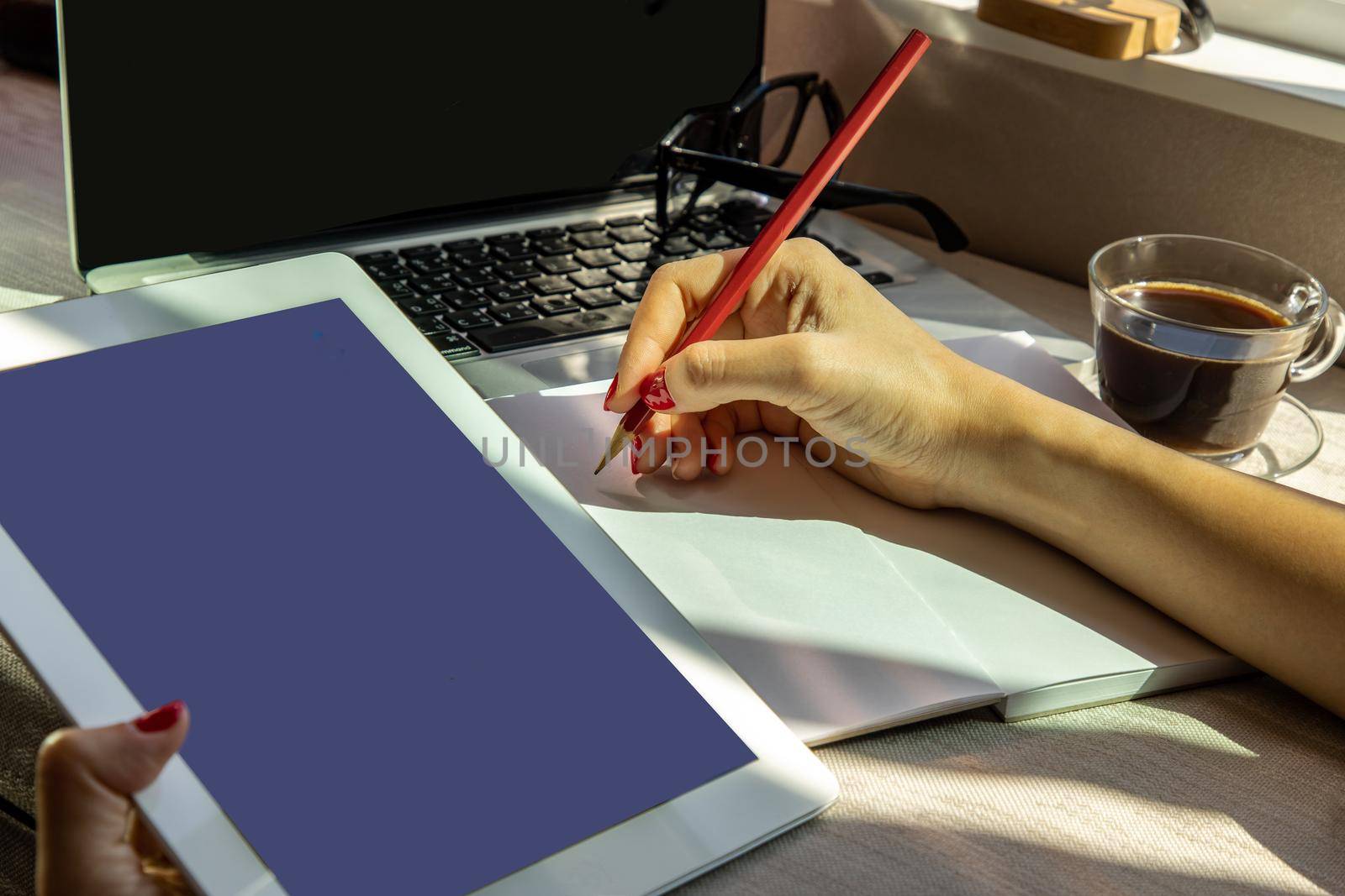 Hand of business woman writing on paper at her workstation. business concept.