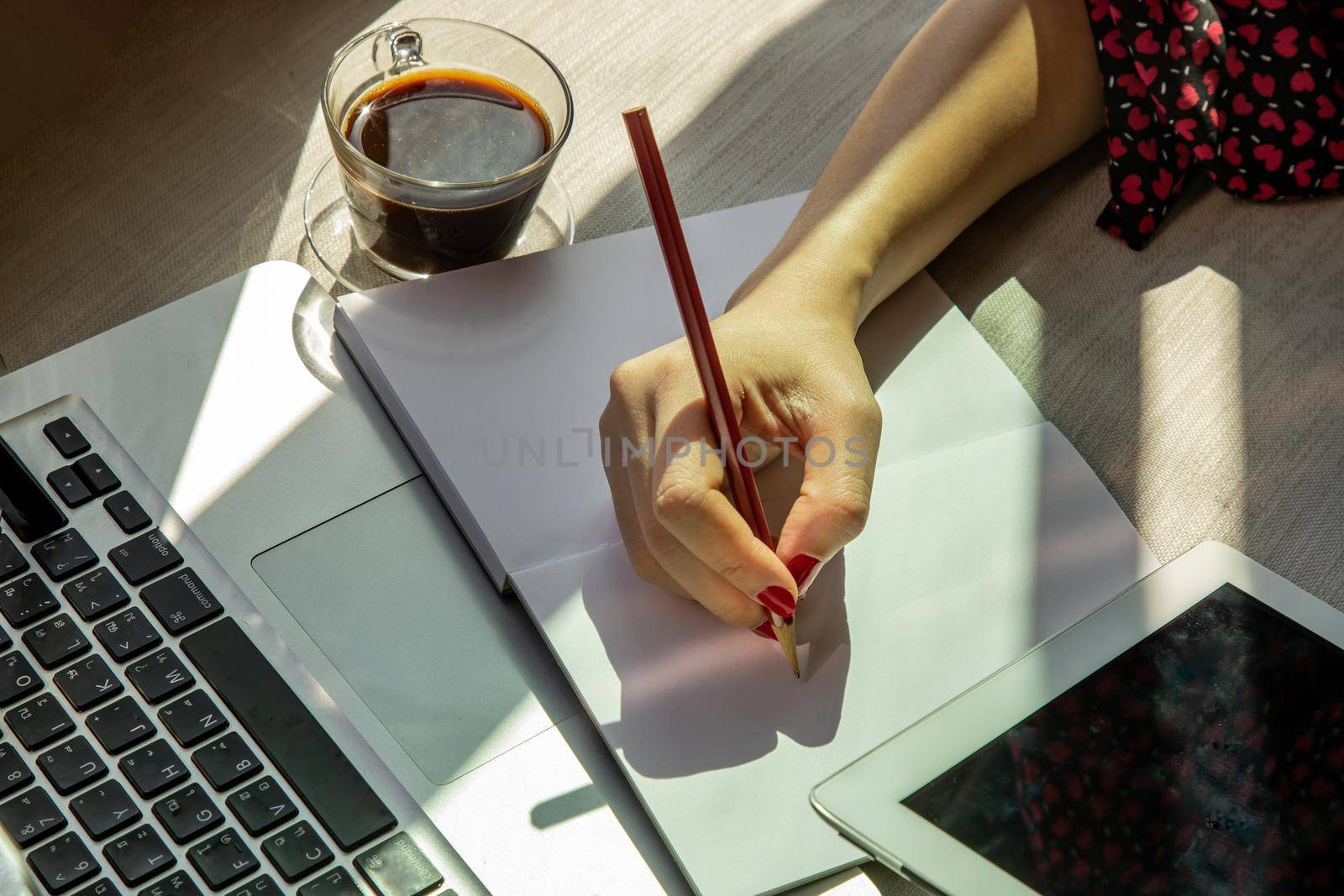 Hand of business woman writing on paper at her workstation. business concept.