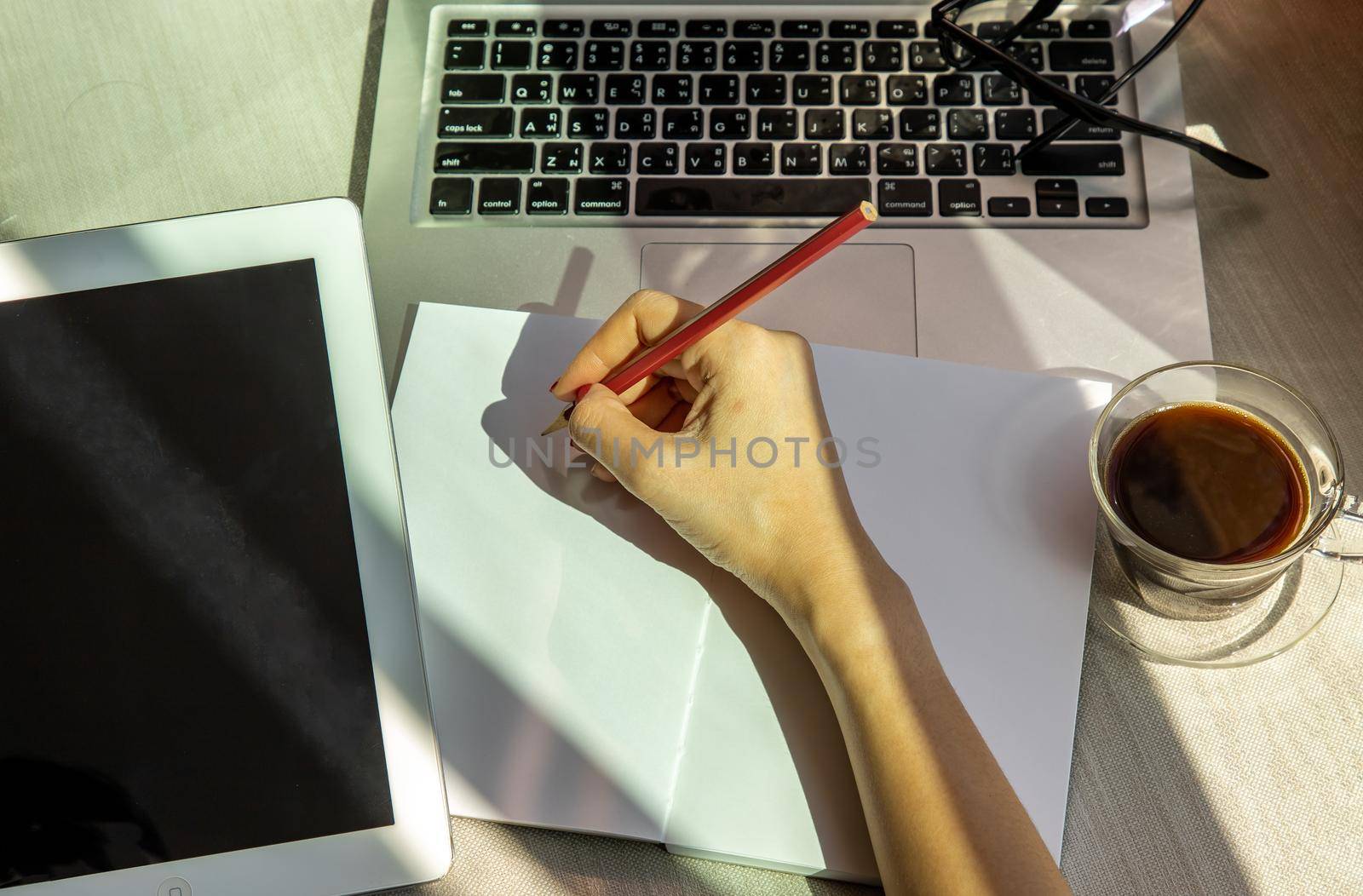 Hand of business woman writing on paper at her workstation. business concept.