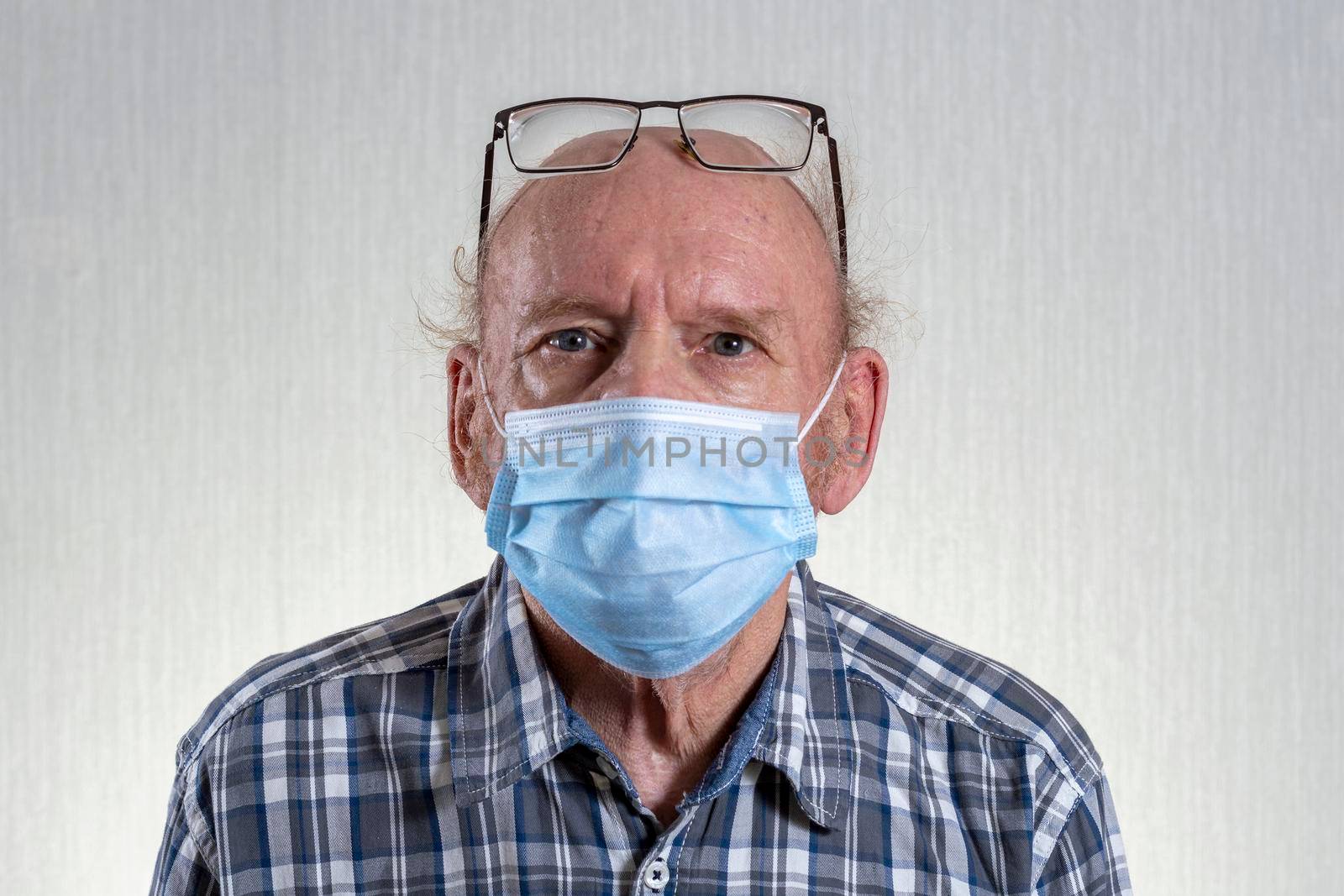 Old bald man with glasses in mask. Indoors in daylight. Front view. by Essffes