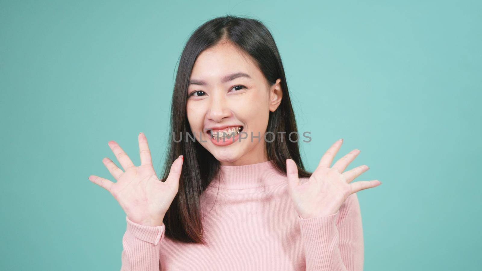 Portrait young Asian happy beautiful woman smiling wear silicone orthodontic retainers on teeth wow and surprised she excited screaming isolated on blue background