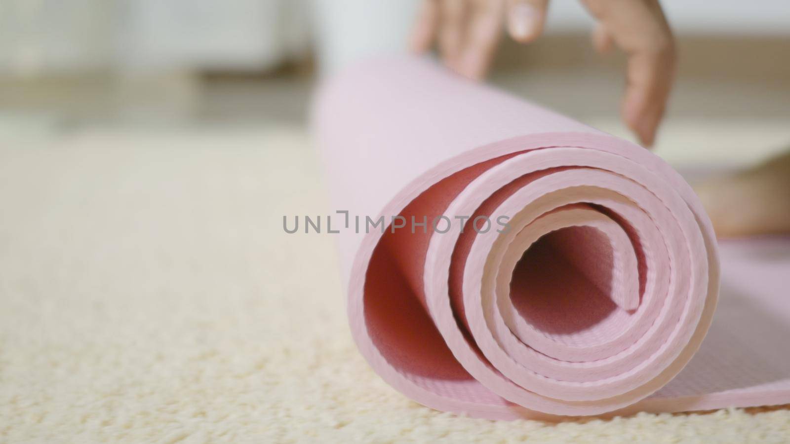 Asian young woman rolling fitness yoga pink mat before sports practice for exercise, female working out at home in the living room. lifestyle sport healthy concept, slow motion from 60fps