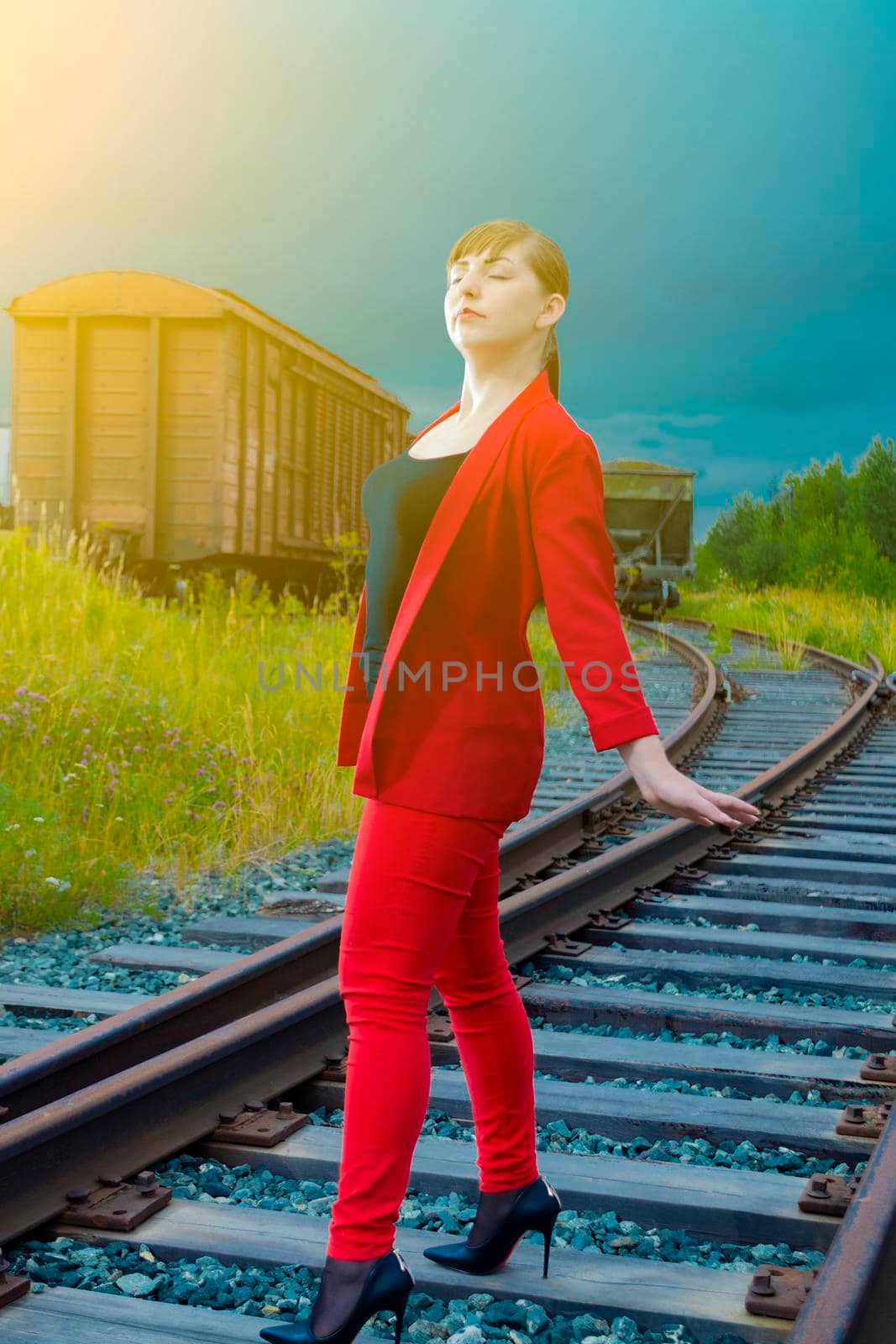 Woman on the rails. In a red trouser suit, the eyes are closed. by Essffes