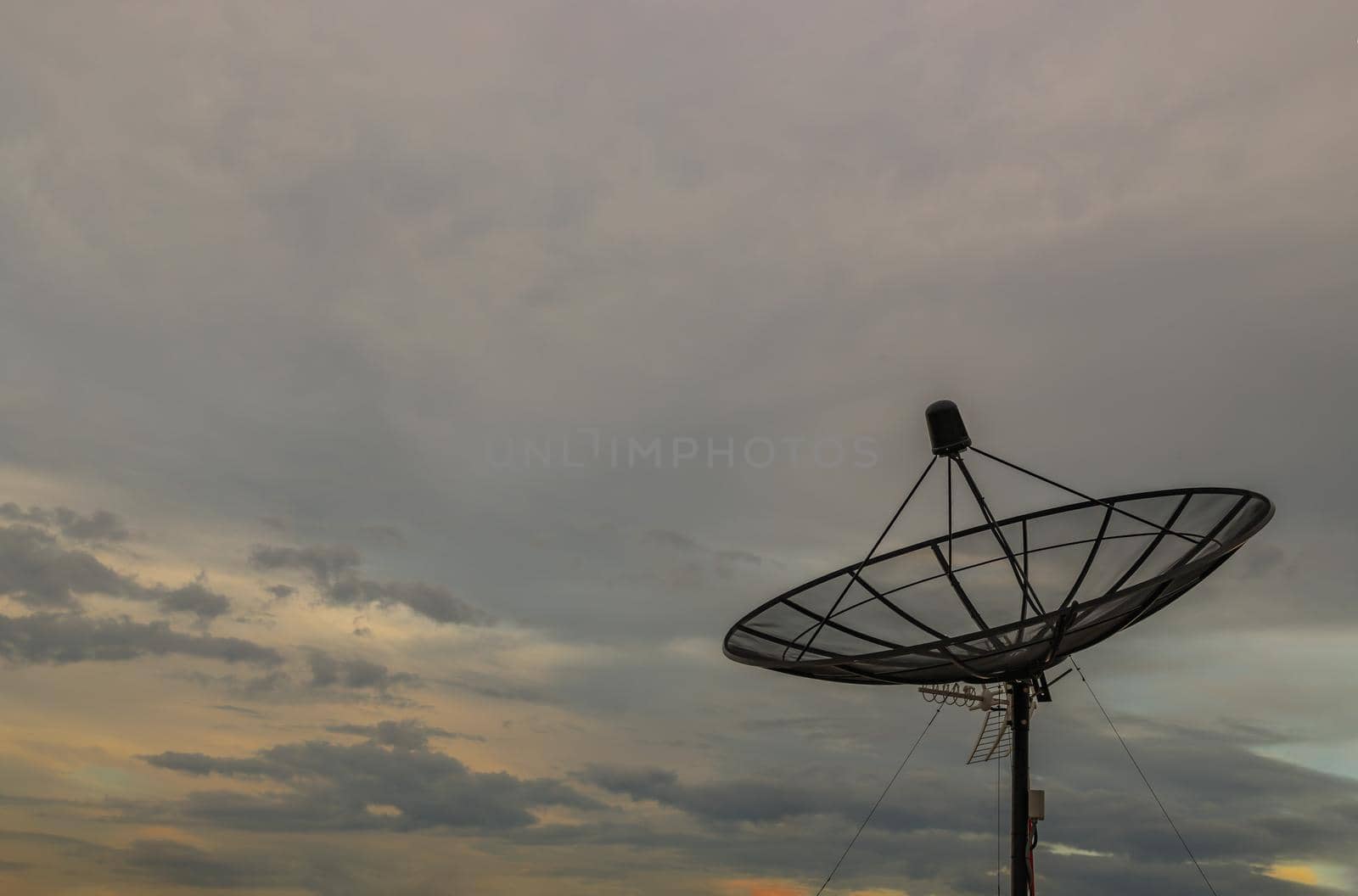Black Satellite Dish Antenna Receiver Against on Blue Sky background for Communication and Media Industry, Symbolizing Global Communications. Free copy space for text, Selective focus.