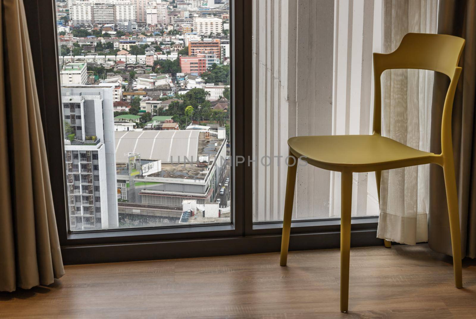 Panoramic windows and single chair in simple room. Selective focus.