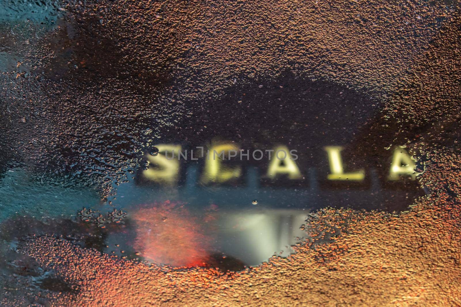 The reflextion of Scala cinema logo in water puddle after the rain.