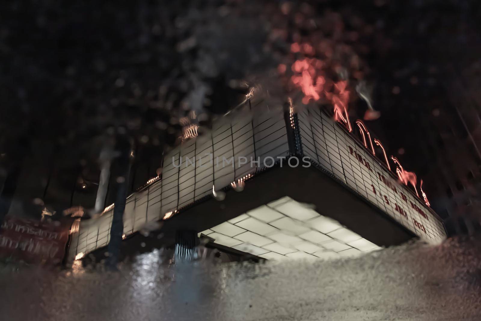 Bangkok, Thailand, Jul 03, 2020 : The reflextion of Scala cinema logo in water puddle after the rain.
