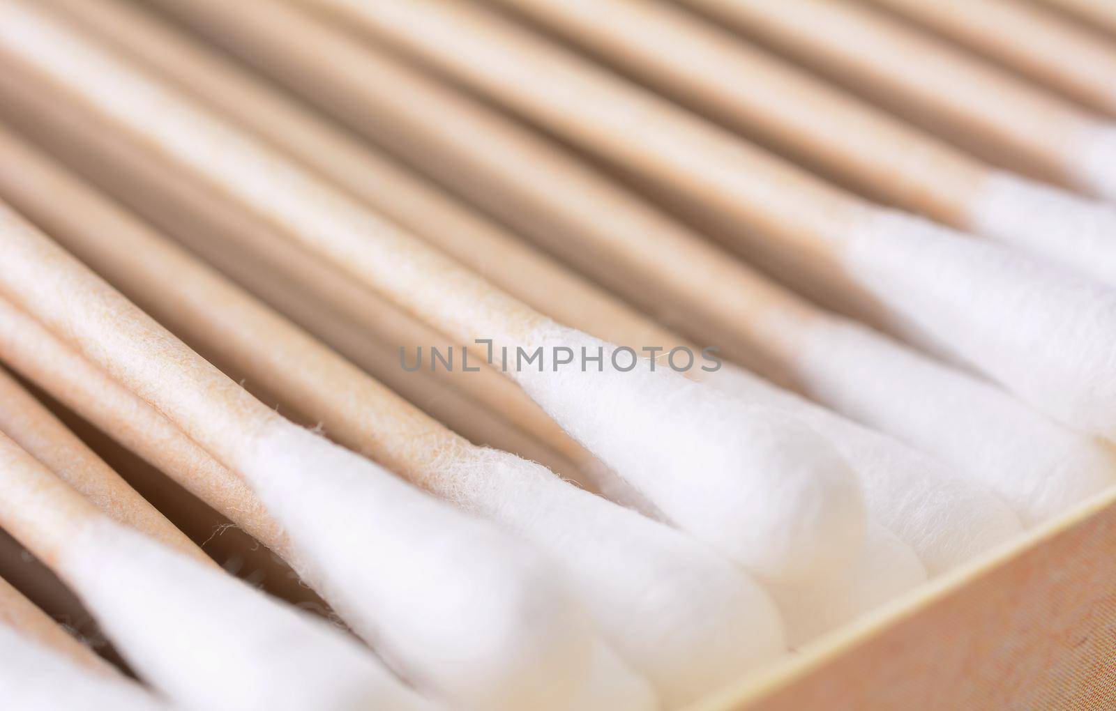 Closeup of the box full of ecological recyclable cleaning cotton swabs from recycled paper. It used for better environmental conservation. Cotton swabs on white background.