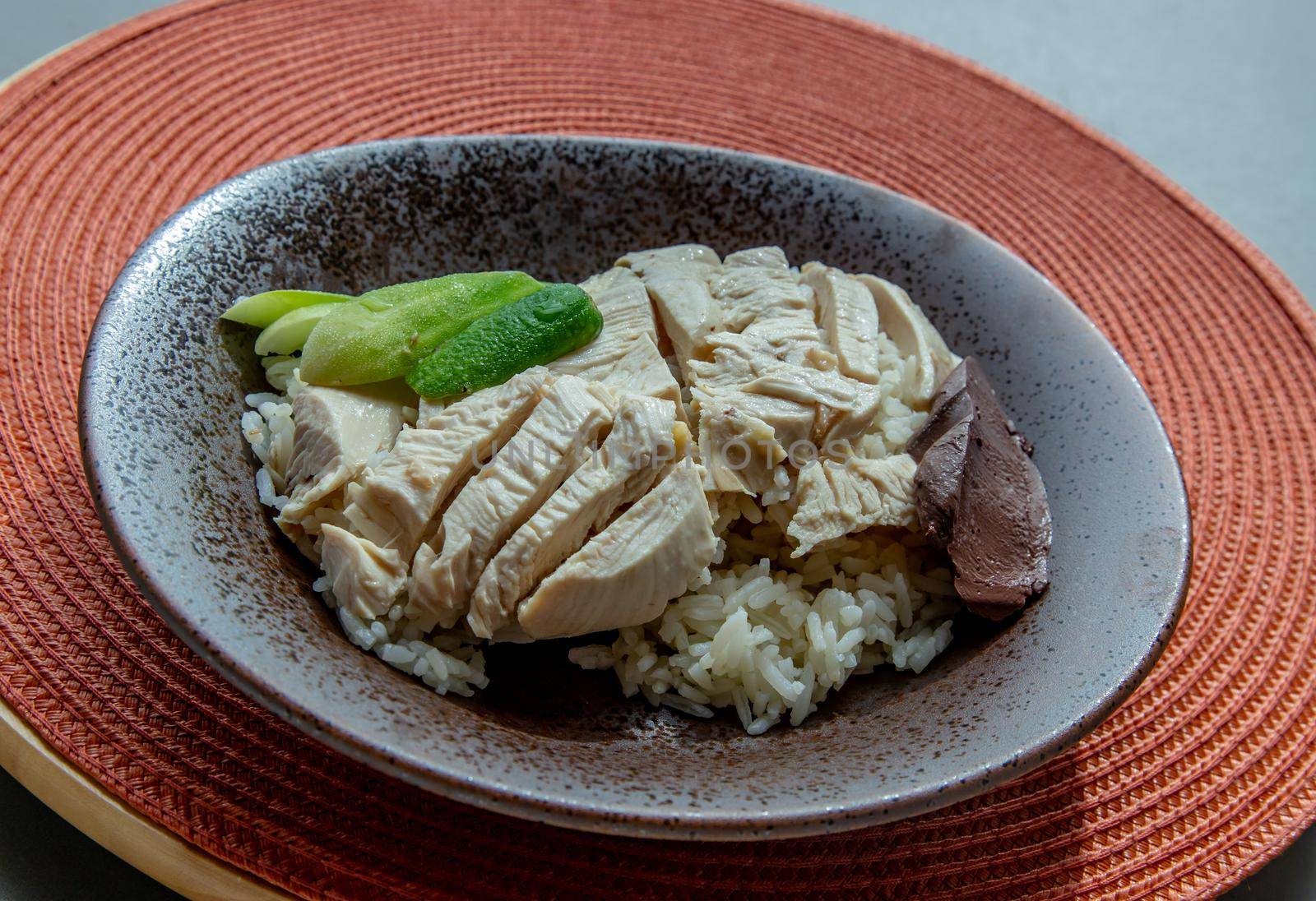 Close-up of Chicken rice on the red round straw table mat. Selective focus.