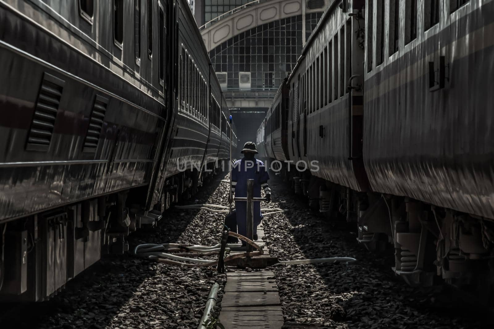 Cleaning staff while cleaning the train at Bangkok Railway Station or Hua Lamphong Railway Station. Focus and blur.