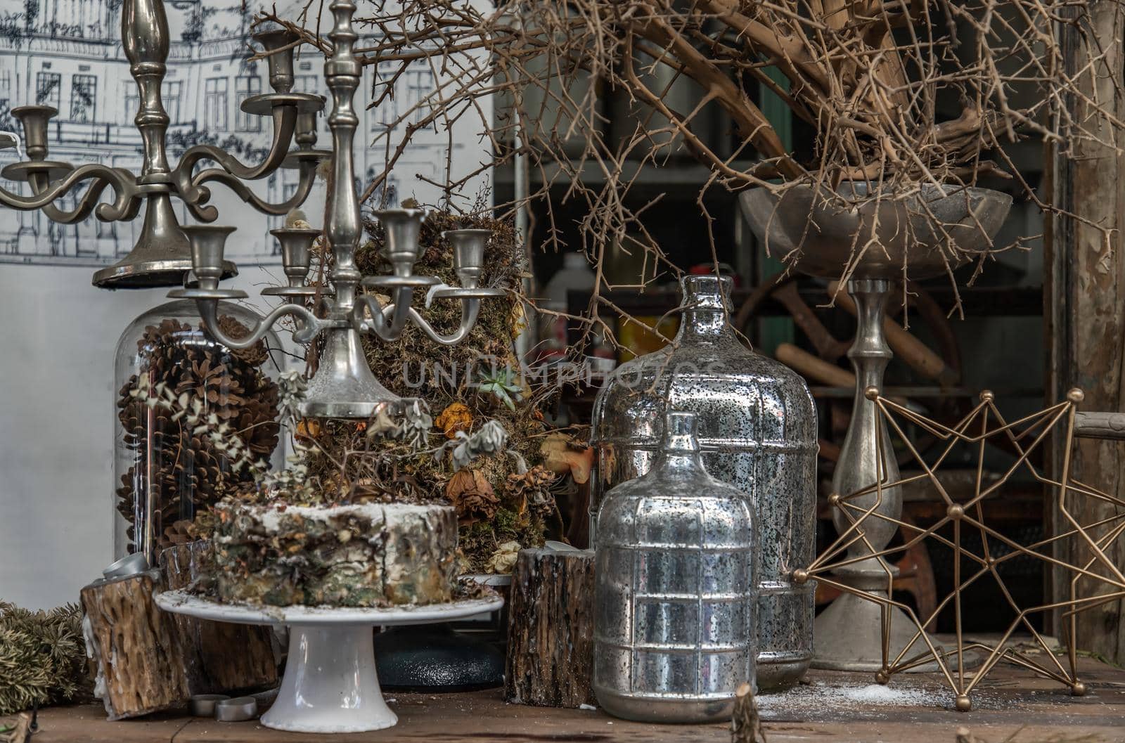 Antique candlestick and Dry plant, Dried flowers, Pine cones with Glass bottle Decorate on wooden table in cafe. Vintage shop decoration idea. Selective focus.