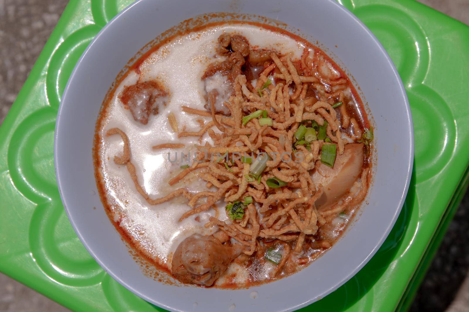 Traditional Khao Soi Recipe, Thai Northern Style Curried Noodle Soup with Chicken in white bowl. Selective focus.