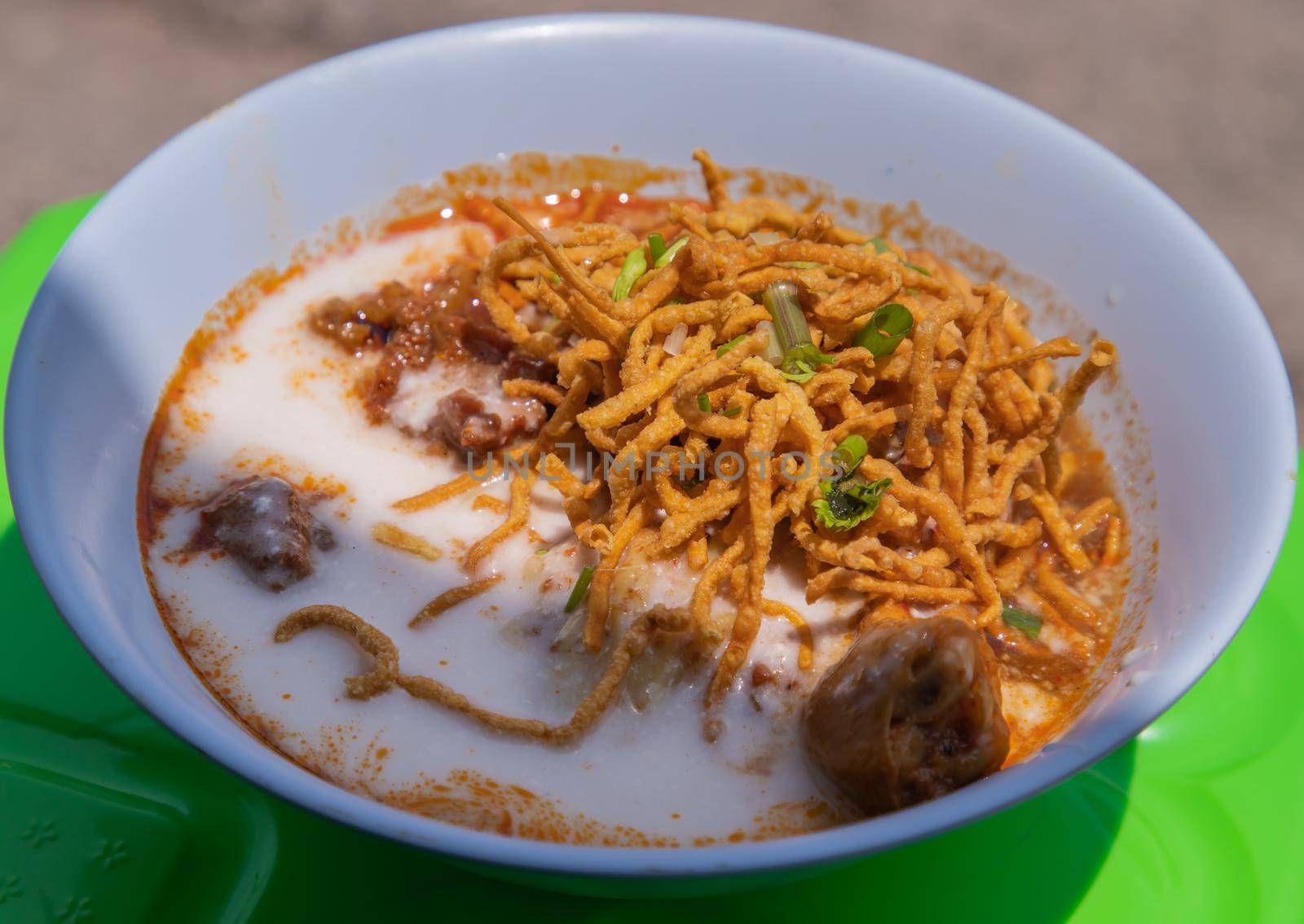 Traditional Khao Soi Recipe, Thai Northern Style Curried Noodle Soup with Chicken in white bowl. Selective focus.