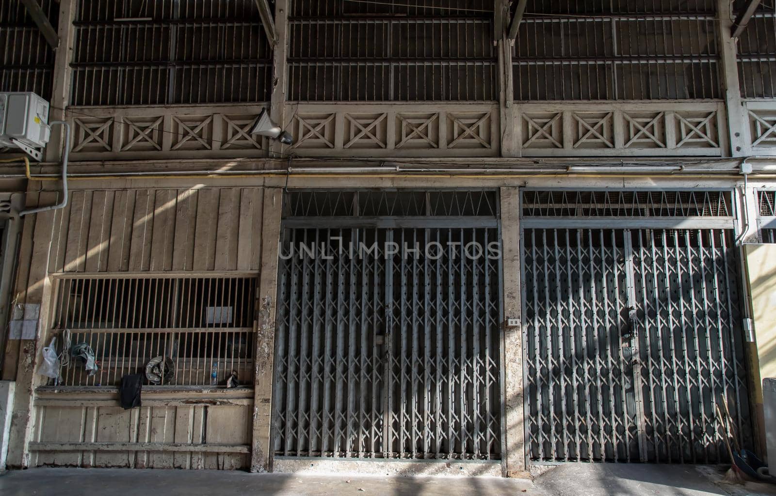 Front view of entrance of the building and old steel metal shutter and folding door gate on old industrl building. No focus, specifically.