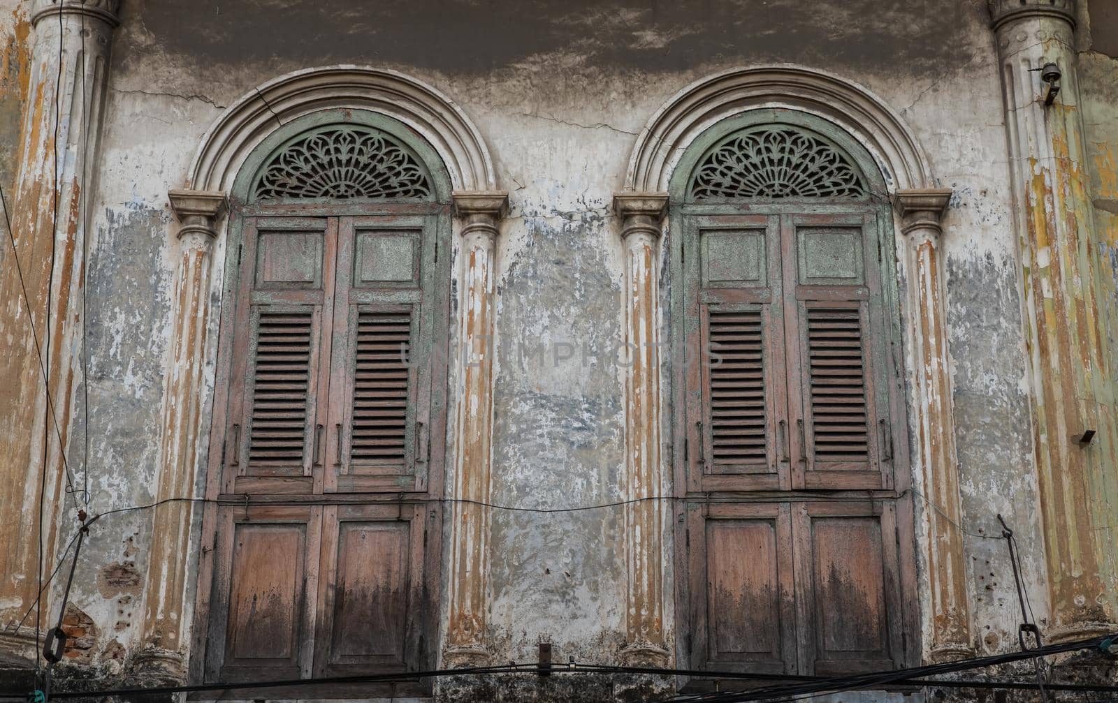 Brown vintage two wooden doors on the old wall. Western Architecture style, Selective focus.