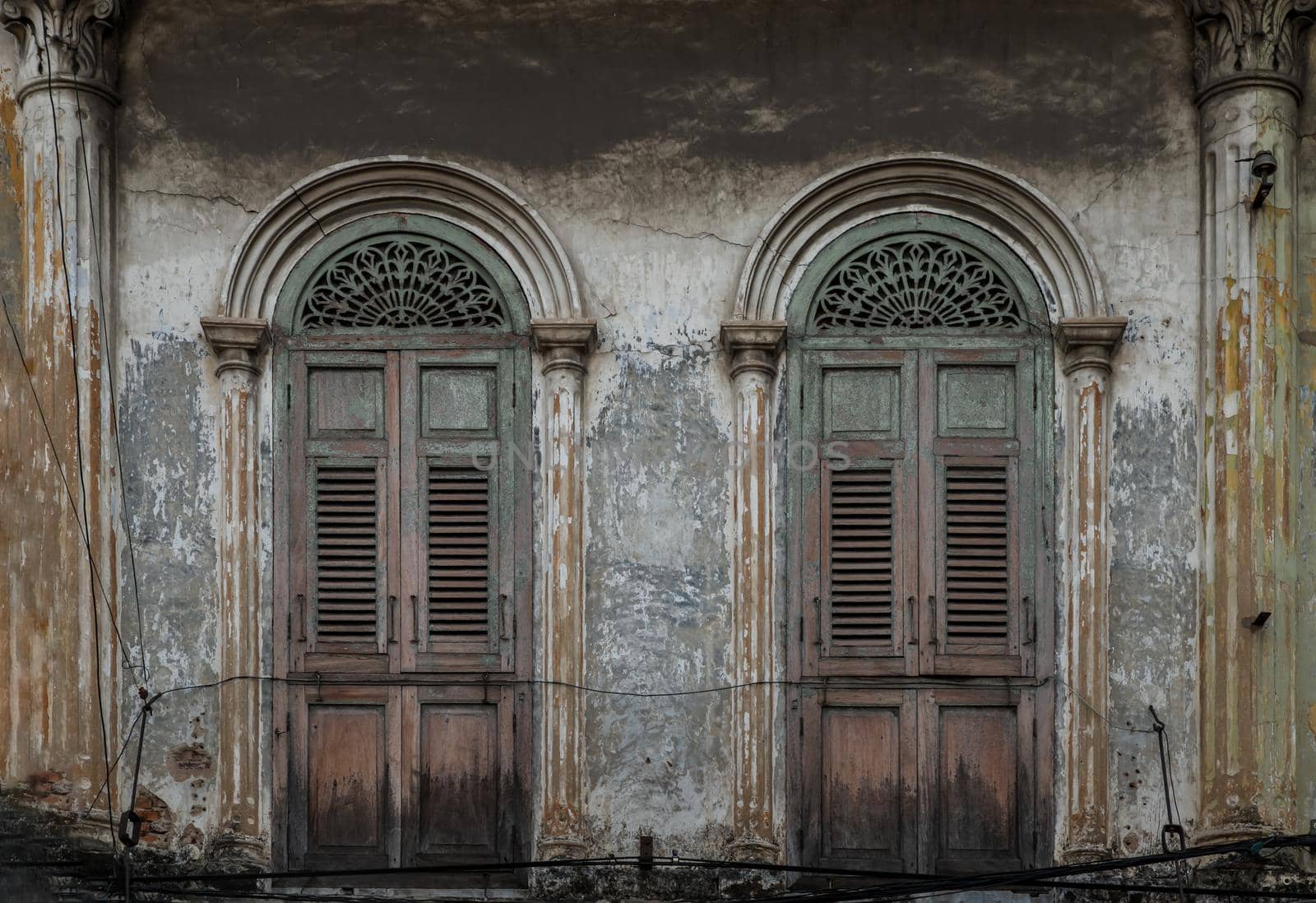Brown vintage two wooden doors on the old wall. Western Architecture style, No focus, specifically.