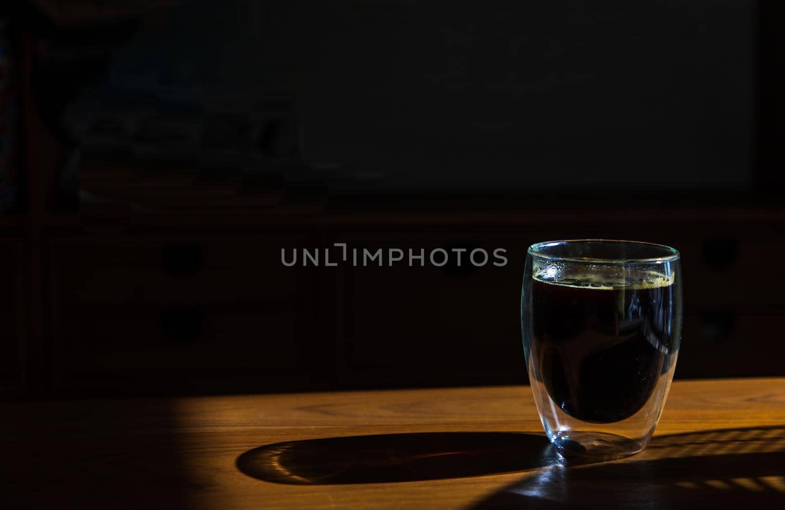 Black coffee in glass cup on wooden table in the room. Coffee style, Copy space, Selective focus.