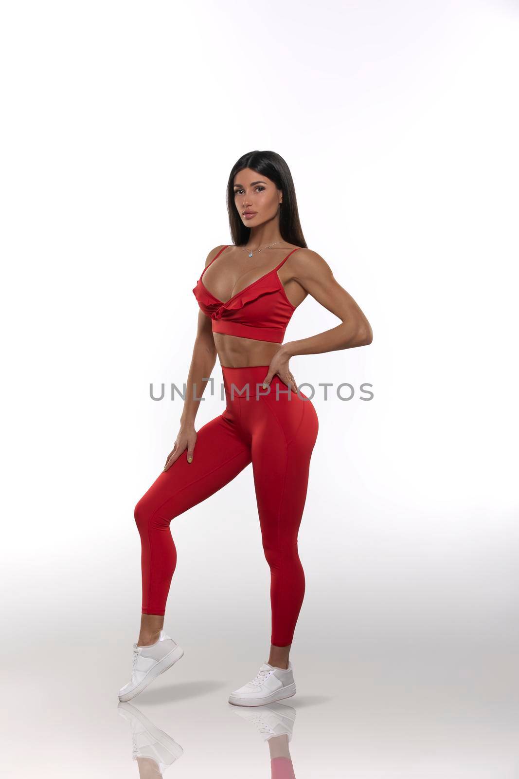 girl in red leggings and a top on a white background by but_photo