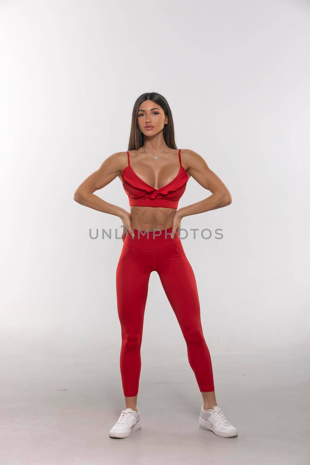 brunette girl in red leggings and a top on a white background