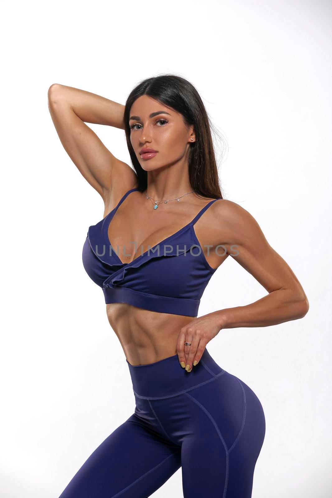brunet girl in blue leggings and top on a white background