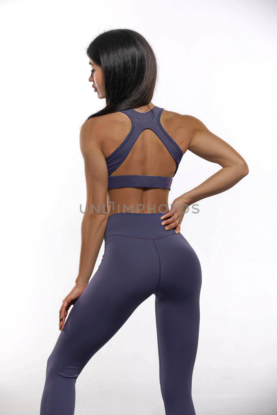 girl in purple leggings and top stay back on a white background by but_photo