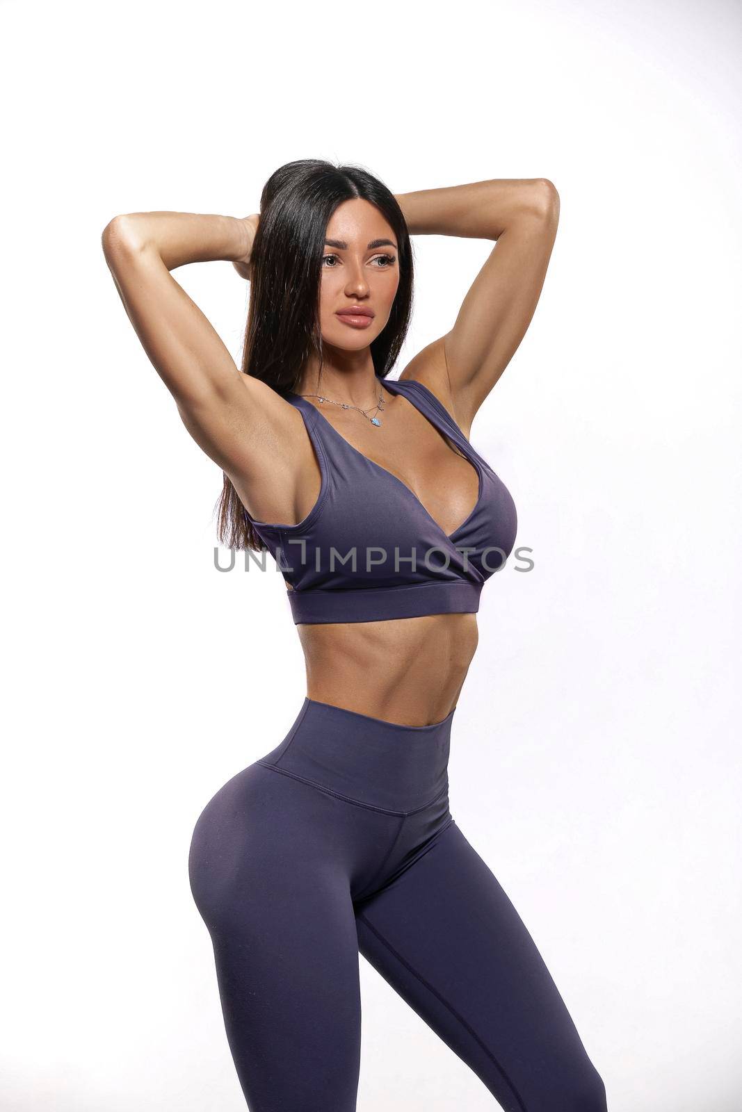 brunette girl in purple leggings and top on a white background